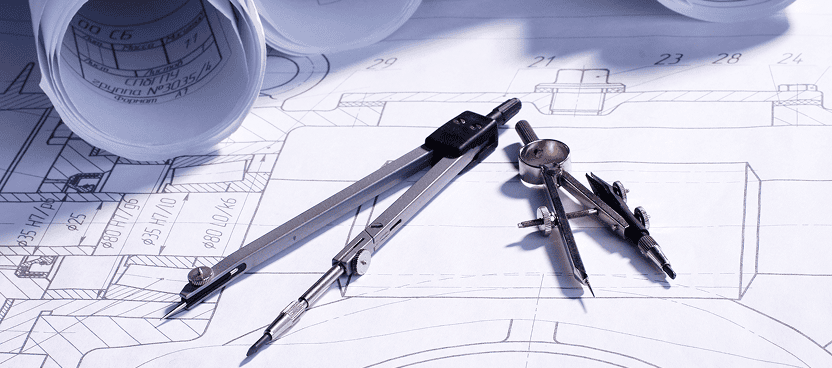Architectural tools and blueprints on a table.