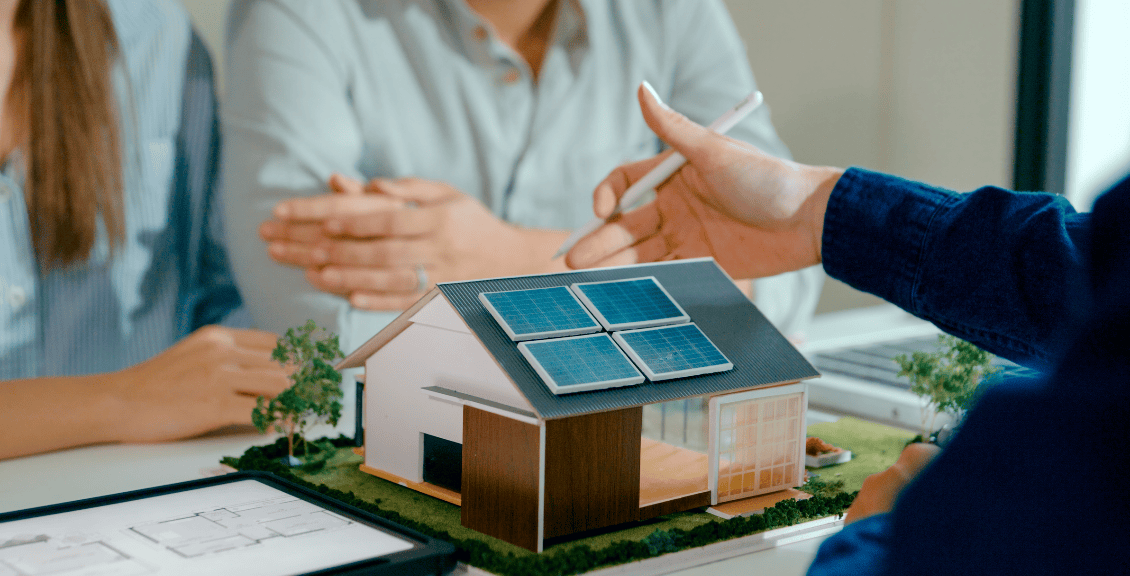 Model house with solar panels on table.