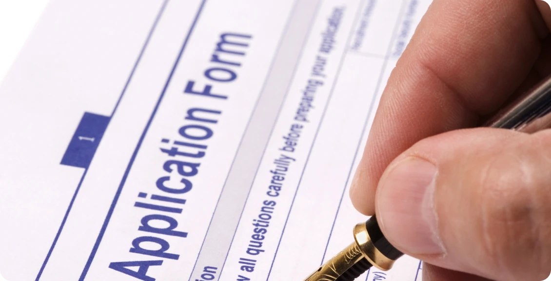 Person writing on application form