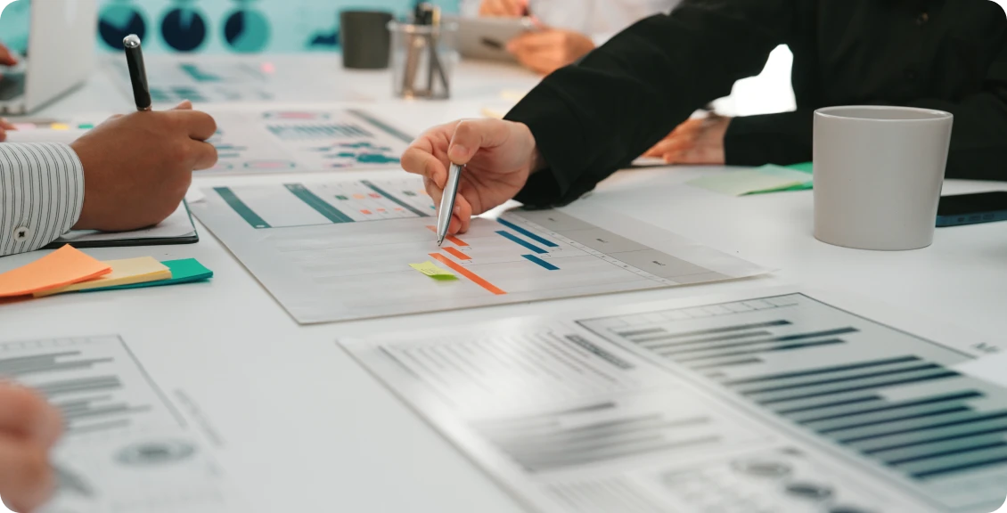 Hands pointing at graphs during discussion